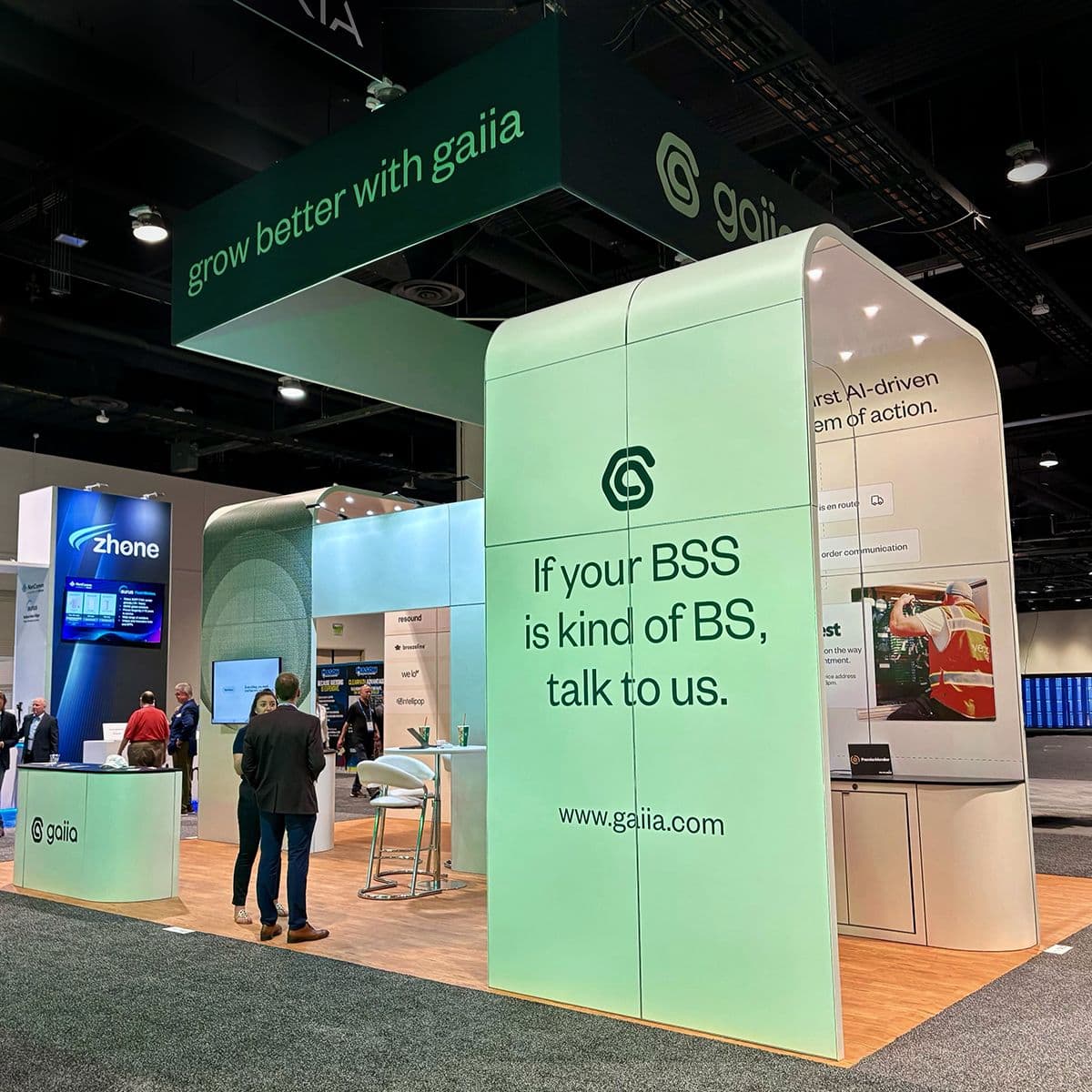 gaiia's trade-show booth, its overhead banner reading "grow better with gaiia" above a mint-green wall that says "If your BSS is kind of BS, talk to us."