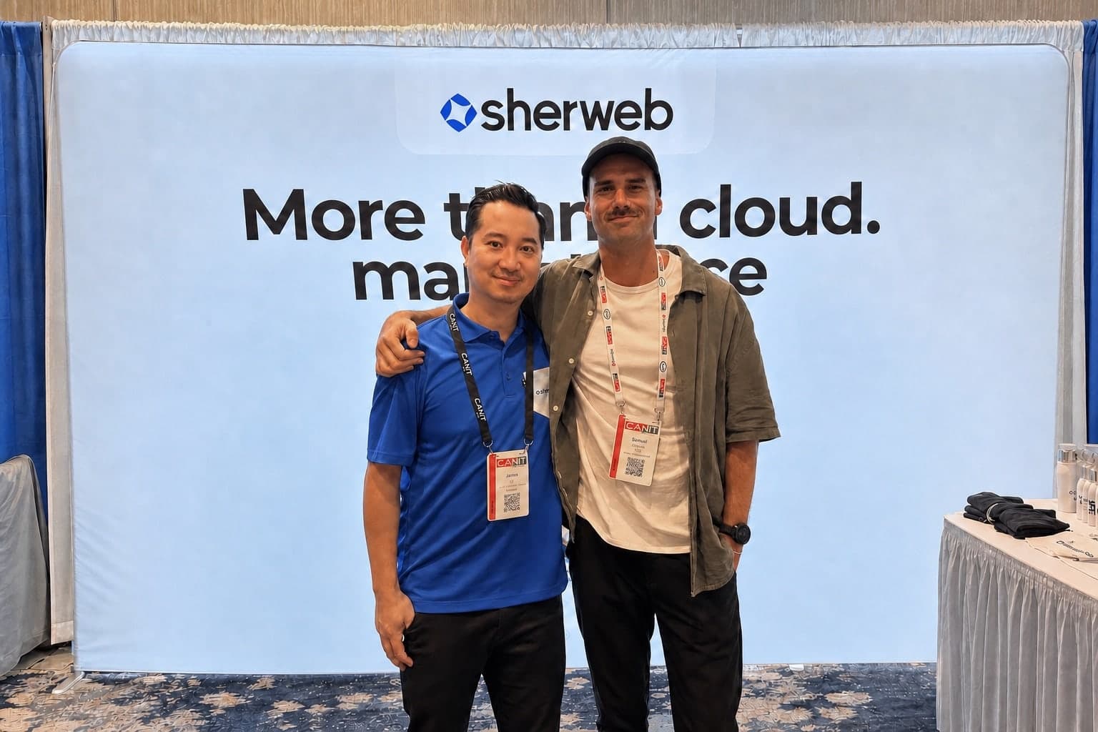 James Sia of Sherweb and Samuel Chenard of Palisade standing together at Sherweb's CanITCon booth, in front of a banner reading "More than cloud", both wearing conference lanyards.
